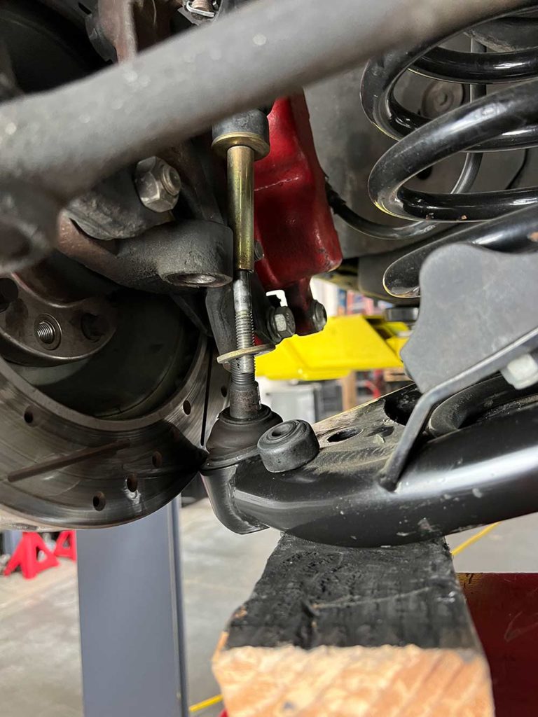 disconnect the sway bar end link and then the lower ball joint